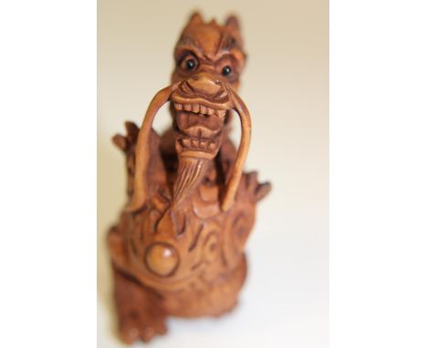 A box wood netsuke in the form of a dragon
