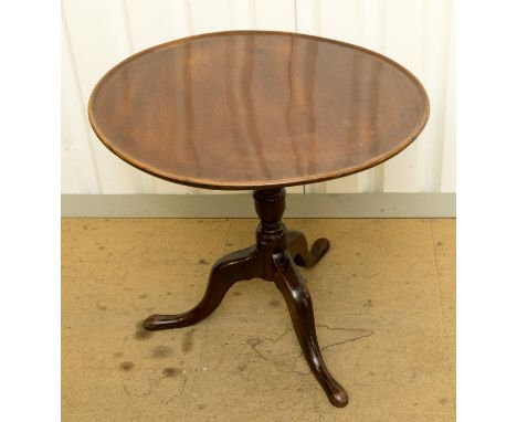 A George III mahogany tilt-top tripod table, the dished circular single plank top raised on a baluster turned column, standin