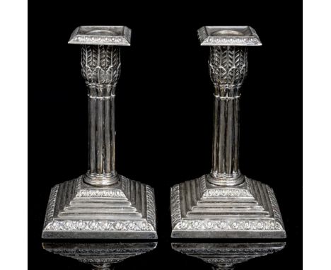 A pair of George V silver loaded candlesticks, of Corinthian form with acanthus leaf detail and stepped base, removable scone