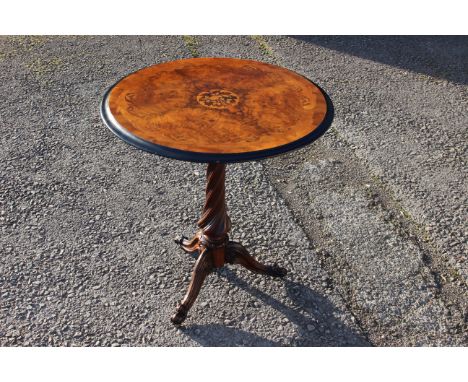 A mid Victorian walnut quarter veneered and marquetry inlaid tripod table, raised on a spiral turned column, standing on thre