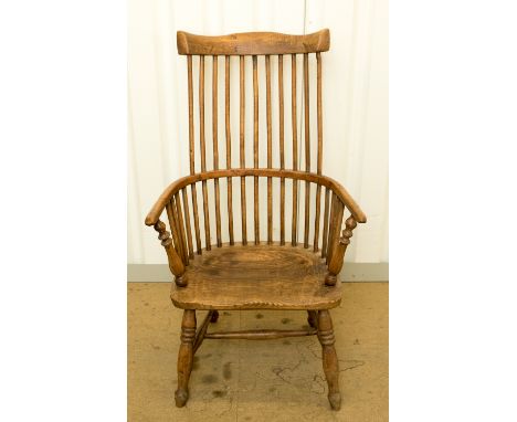 An 18th century elm, beech and ash comb back Windsor chair, with a saddle seat, raised on splayed legs, 102cm high, 60cm wide