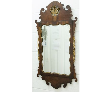 A George II walnut veneered looking glass, with fretwork applied embellishments, gilded fretwork to sides, gilded shell finia