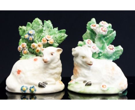 A pair of Derby models of recumbent sheep, 18th Century, beside bocage trees, patch mark bases, height 7cm (2)