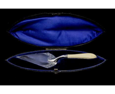 A Victorian presentation trowel, having a worked ivory handle and silver triangular shaped blade engraved with foliate decora