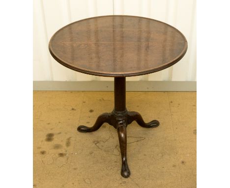 A George II oak tilt-top tripod table, with a dished circular top, raised on a barrel turned column, standing on cabriole leg