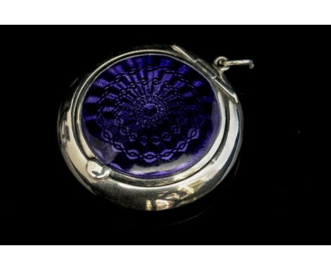 A George V silver and enamel compact, of circular form, hinged cover with violet guilloche enamel, which opens to reveal an i