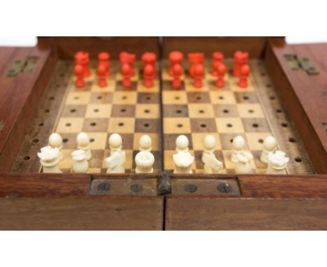 A mahogany miniature campaign or travelling chess set, late 19th Century, hinged and opening to a parquetry chess board with 
