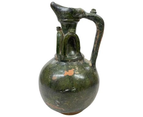 An Umayyad green glazed pottery ewer, Syria, 8-9th century, with spherical body and tubular neck, appled decoration, light su