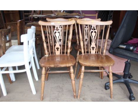 A set of four stick back dining chairs 