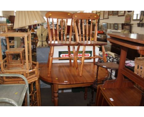 A pine extending dining table with two stick back dining chairs 