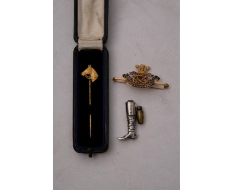 A 9ct gold Horse head stick pin by Garrard &amp; Co, Ltd,: together with a continental silver riding boot charm and a 15ct go