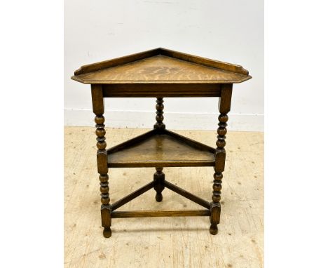 A 1920s oak two tier corner hall table on bobbin turned supports (h.84cm x l.70cm)