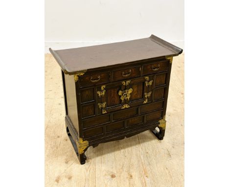 A Korean elm brass mounted treasure style chest with upswept top, fitted three drawers and two panel doors (h.52cm x l.66cm x