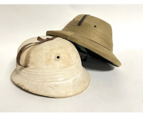 A Calcutta Sola Hat Agency pith helmet with chin strap (h. x 15cm x 25 cm) together with a Walter Barnard &amp; Son polo helm