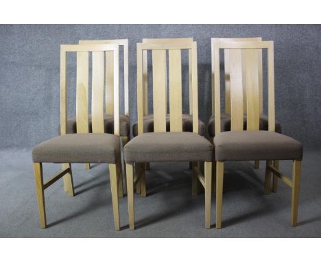 A set of six contemporary slat back light oak dining chairs with upholstered seats on square tapering supports. 