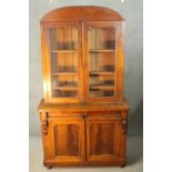 A late 19th century mahogany library bookcase with upper glazed section above drawers and panel