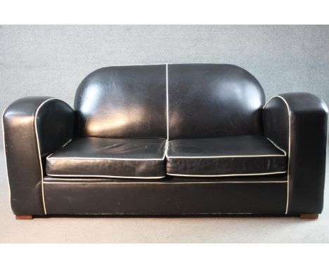 An Art Deco two seater sofa in piped leather upholstery on block supports. H.80 W.170 D.85 cm 