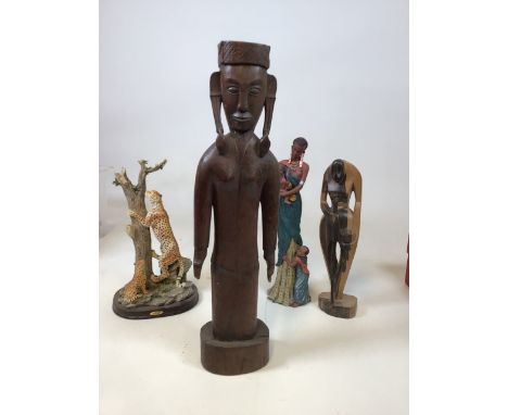 A carved Eastern figure with another wooden figure, a ceramic Naisianoi figure and a leopard 