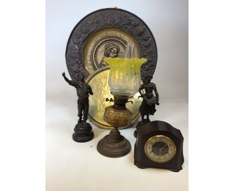 Brass chargers, an oil lamp, a pair of spelter figures and a Smiths Bakelite clock 