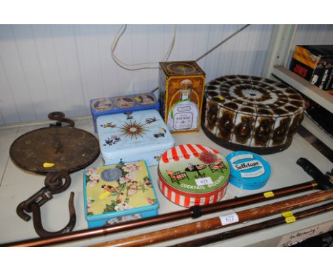 A ceiling light shade, a collection of advertising tins, a set of hanging scales