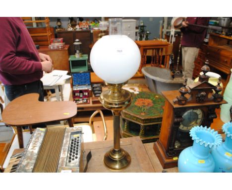 A  brass oil lamp with milk glass shade