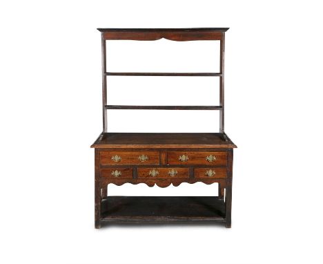 AN ENGLISH 18TH CENTURY STAINED OAK DRESSER OF COMPACT FORM, with shaped cornice above two open back shelves, on a rectangula