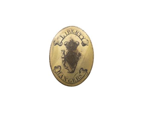 AN OVAL GILT BRASS BELT-BADGE, engraved with a crowned harp and round-about 'LIBERTY RANGERS', gadrooned rim, 8.25 x 6cmProve