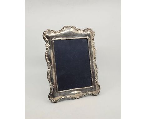 A silver easel back photograph frame, by Mappin &amp; Webb Ltd, Sheffield 1990, having scroll border, height 27cm.