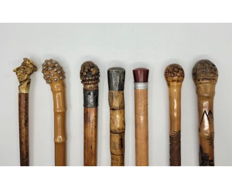 Seven various walking canes/sticks, to include: a cane sword stick, having 74.5cm fullered triangular blade and handle inset 