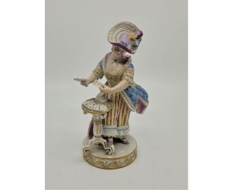 A late 19th century Meissen porcelain figure of a standing lady playing cards at a table, after the 18th century model by M.V