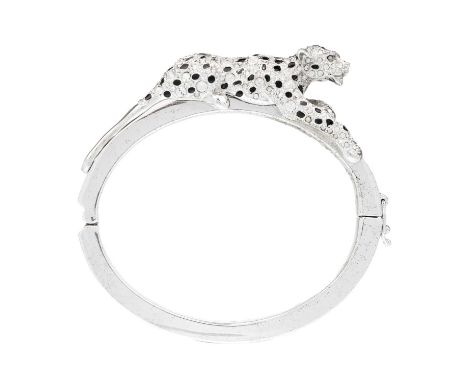 A Bill Skinner snow leopard bangle. A silver bangle featuring Swarovski crystals and black enamel spots and a secure catch fa