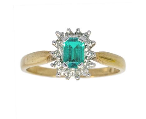 A modern 9ct emerald and diamond set cluster ring. The emerald of 0.60ct approximately, surrounded by 15 small round diamonds