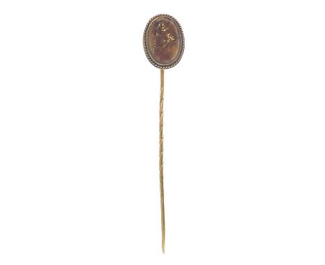 A 9ct stick pin, the oval head with gold bearing ore. length 75mm, 3g.