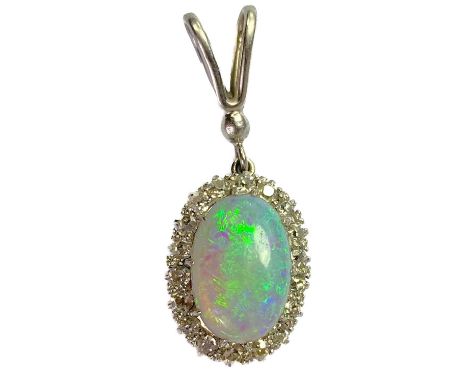 A white opal and diamond cluster white gold pendant. The oval opal with green, purple and yellow colours measuring 11 x 7mm, 