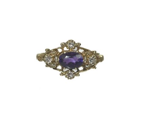 A modern 9ct Edwardian style amethyst and diamond five-stone ring. Of openwork scroll design, the oval cut amethyst measuring