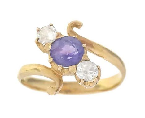 A high purity gold (tests 18ct) sapphire and white topaz set three-stone crossover ring, The purple round cut sapphire measur