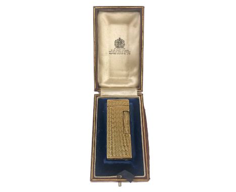 An Alfred Dunhill 9ct gold engine turned lighter with fitted original box. The lighter hallmarked London 1965, length 6.5cm.