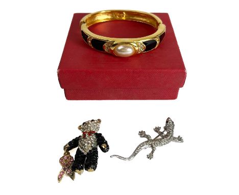 A Napier Bangle and two Butler and Wilson brooches. Comprising a gold plated bangle with black enamel and faux pearl, a lizar