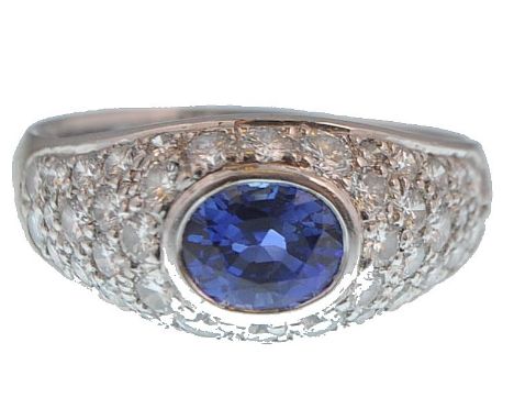 An 18ct French import assay mark white gold sapphire and diamond bombe / dome head ring. Marked 750, the ring with central ov