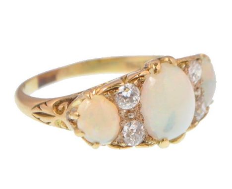 An 18ct gold opal and diamond ring. The ring being set with 3 cabochon large opals with old diamond spacers. Total estimated 