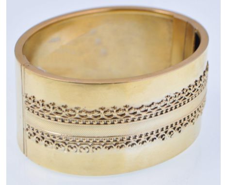 A Victorian 19th century large gold pinchbeck bangle marked B applied with engine turned and filigree worked decorated banded