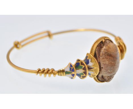 A yellow gold Egyptian revival and enamel scarab bracelet bangle. The bracelet decorated with enamelled sacred lotus and papy