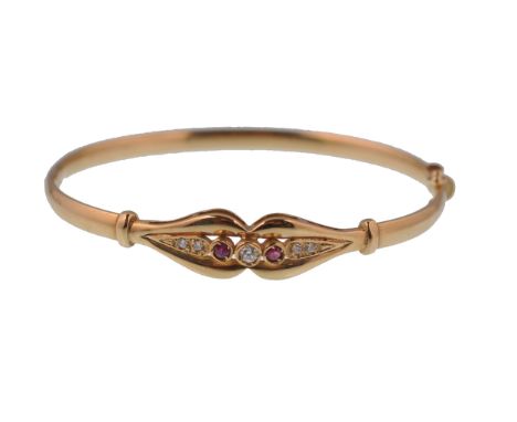 A 9ct gold 375 marked hollow cast ruby and diamond ladies bracelet bangle&nbsp; having clip clasp. The 2 ruby stones flanked 