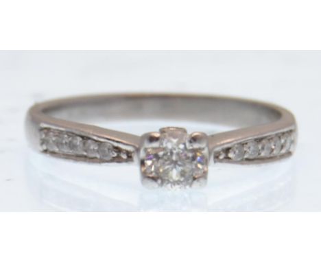 A 950 platinum and diamond solitaire ring having diamond set shoulders. The central brilliant cut diamond of approx 20pts. We