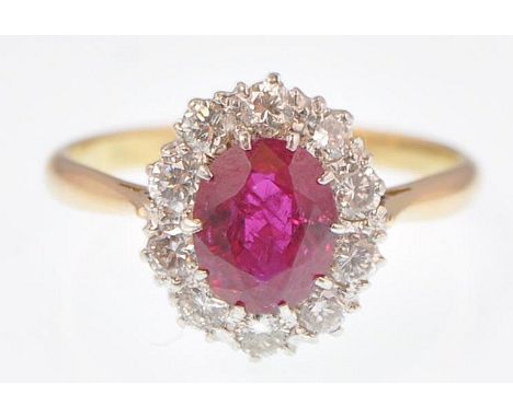An 18ct gold and platinum ruby and diamond cluster ring. The central ruby estimated weight 1.20ct, estimated diamond weight 0