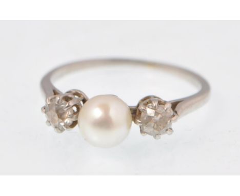 A 1920's pearl and diamond ladies platinum ring. The ring set with a central cultured pearl flanked by 2 old cut diamonds app