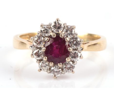 A ruby and brilliant cut diamond oval cluster ring, in 18 ct yellow and white gold, hallmarked London 1992, ring size L 1/2.C