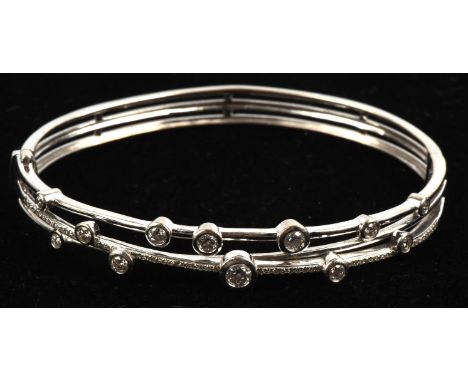 Diamond spray hinged bangle, bezel set with round brilliant diamonds of varying sizes on a multi-band design, with the centre