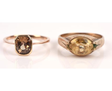 Two single stone rings, including a bezel set brown zircon ring, in 9 ct, size N, and a claw set oval cut citrine ring, in 9 