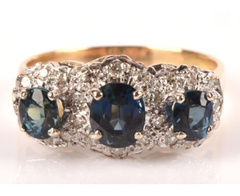 Sapphire and diamond dress ring, set with three oval cut sapphires, surrounded by single cut diamonds, mount testing as 18 ct